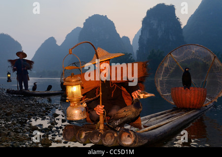 I pescatori cinesi con i cormorani all'alba sul fiume Li e alta formazione carsica montagne yangshuo cina Foto Stock