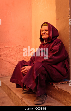 Anziani uomo seduto sui gradini, Marrakech, Marocco Foto Stock