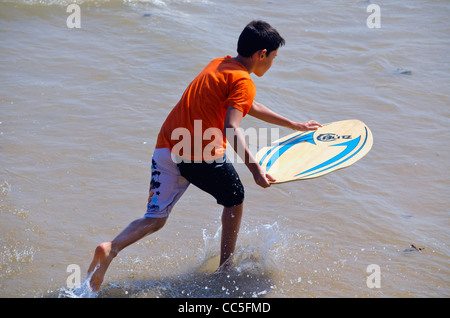 Ragazzo surfboarding in mare Foto Stock