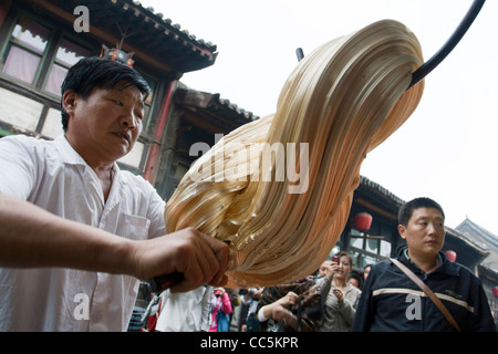 L'uomo tirando lo zucchero, antica Ming-Qing Street, Pingyao Città Antica, Jinzhong, Shangxi , Cina Foto Stock