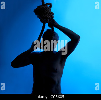 Una silhouette di un uomo collocando un cappio intorno al suo collo Foto Stock