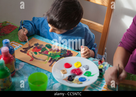 Bambino dipinge con colori Foto Stock