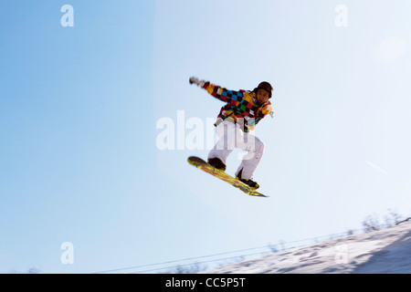 Giovane uomo su skateboard in mid-aria, Lianhua Mountain Ski Resort, Changchun, Jilin , Cina Foto Stock