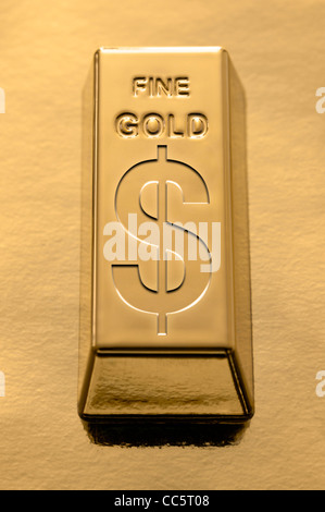 Gold bar con un simbolo del dollaro incisi su un fondo dorato Foto Stock