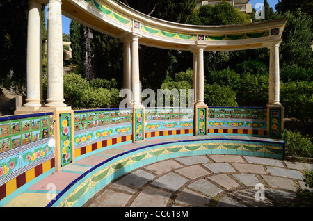 Rotunda piastrellata in ceramica e panca da giardino in cemento circolare decorata con Don Chisciotte piastrelle in ceramica Fontana Rosa Giardino Mentone Alpes-Maritimes Francia Foto Stock