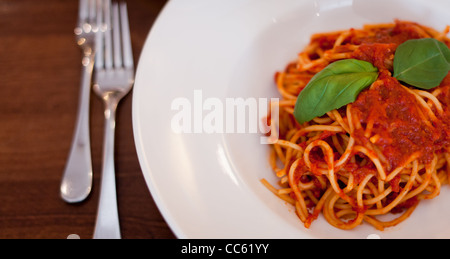 Spaghetti alla bolognese su una piastra con posate Foto Stock
