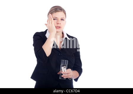 Ritratto di giovane donna con il mal di denti, tenendo il vetro con acqua e compresse. Isolato su sfondo bianco. Foto Stock