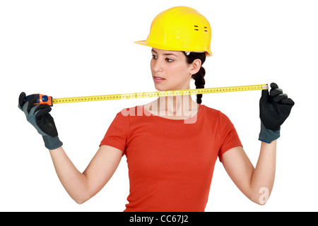 Tradeswoman utilizzando un nastro di misurazione Foto Stock