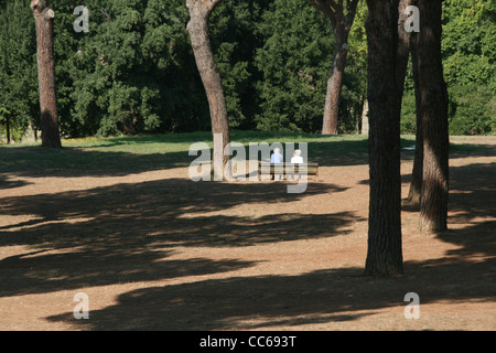 Vecchia coppia seduta sulla panchina nel parco di Villa Pamphili a roma Foto Stock