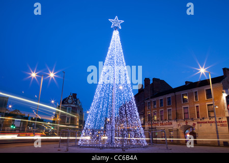 L'accensione di un albero di Natale con Stella sulla parte superiore di notte con auto sentieri di luce Nottingham England Regno Unito Foto Stock