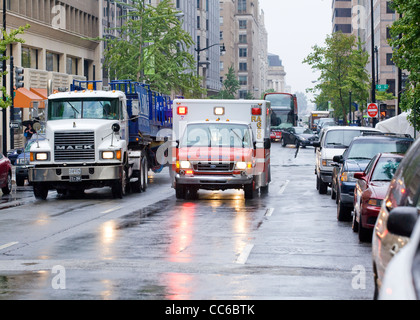 Un ambulanza racing giù per una strada di città in un giorno di pioggia - Washington DC, Stati Uniti d'America Foto Stock