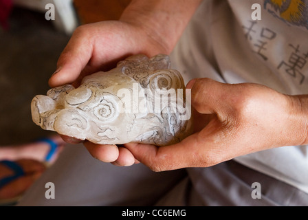 L'uomo tenendo un incompiuto di figurine di giada, Tengchong, Baoshan, Yunnan , Cina Foto Stock