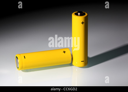 Giallo due batterie AA in un fascio di luce. Ecologia concetto energetico. Foto Stock
