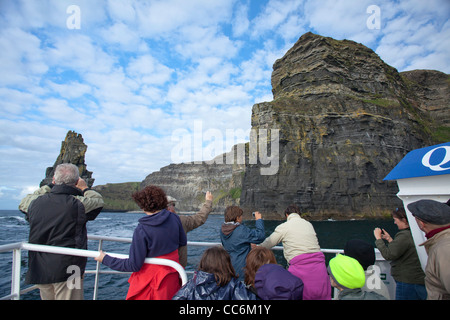 Ai turisti di ammirare le scogliere di Moher da un panoramico tour in barca, County Clare, Irlanda. Foto Stock