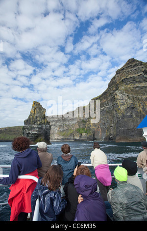 Ai turisti di ammirare le scogliere di Moher da un panoramico tour in barca, County Clare, Irlanda. Foto Stock