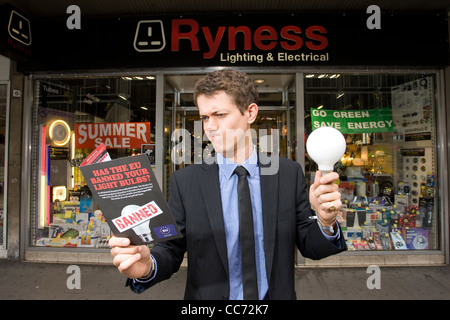 L'uomo contempla che tipo di lampadina per acquistare in negozio elettrica come energia-luce inefficiente le lampadine possono essere eliminate gradualmente. Foto Stock