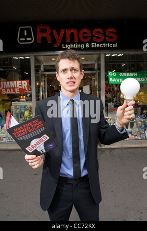 L'uomo contempla che tipo di lampadina per acquistare in negozio elettrica come energia-luce inefficiente le lampadine possono essere eliminate gradualmente. Foto Stock