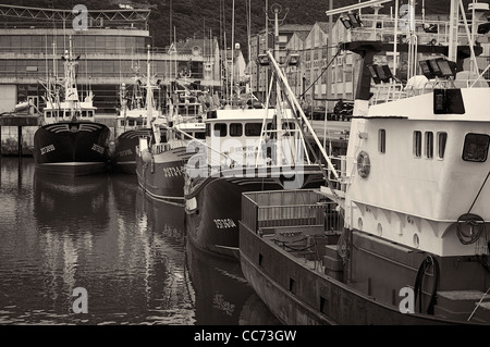 Foto in bianco e nero del porto con la pesca barche ormeggiate in Santona ed il mercato del pesce in background, Cantabria, Spagna settentrionale, l'Europa. Foto Stock