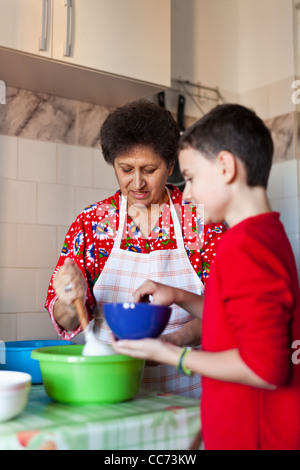 Kid aiutare sua nonna rendendo i cookie in cucina Foto Stock