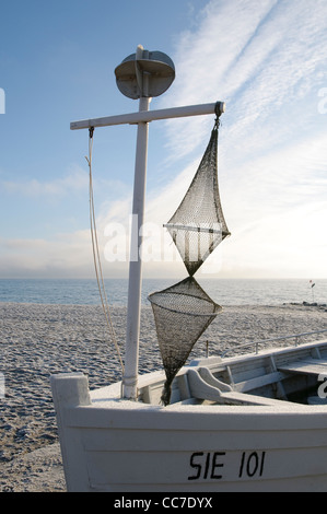 Barca con una rete da pesca su una spiaggia in inverno, Sierksdorf, Luebeck Bay, Mar Baltico, Schleswig-Holstein, Germania, Europa Foto Stock