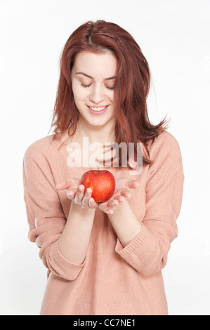 Sorridente giovane donna azienda apple Foto Stock
