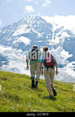 Backview del giovane escursionismo, Oberland bernese, Svizzera Foto Stock