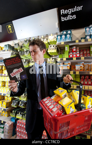 L'uomo contempla che tipo di lampadina per acquistare in negozio elettrica come energia-luce inefficiente le lampadine possono essere eliminate gradualmente. Foto Stock