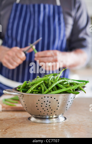 Uomo in cucina con verdure in cucina, Cape Town, Western Cape, Sud Africa Foto Stock