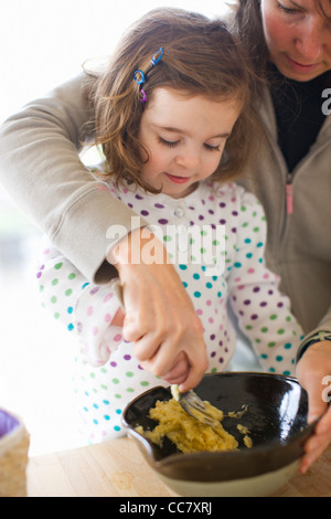 Madre e figlia nella preparazione degli alimenti in cucina Foto Stock