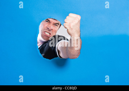 Uomo che guarda attraverso il foro Foto Stock