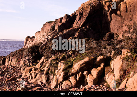 Gennaio sole che splende sulle rocce al traghetto di Broughty spiaggia lungo il fiume Tay estuario a Dundee, Regno Unito Foto Stock