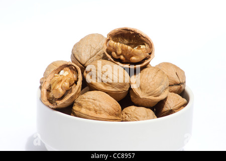Le noci in una ciotola bianco su sfondo bianco Foto Stock