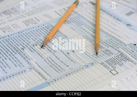 Due matite affilate sedersi sulla tassa di IRS moduli pronti per calcolare Foto Stock