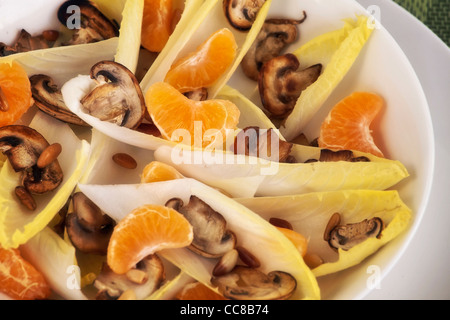 Le cicorie di Bruxelles con insalata di arance mandarini, funghi e pinoli Foto Stock