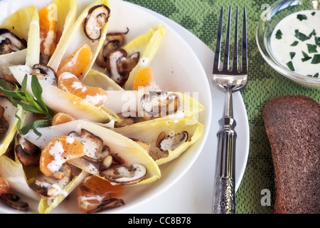 Le cicorie di Bruxelles con insalata di arance mandarini, funghi e pinoli Foto Stock