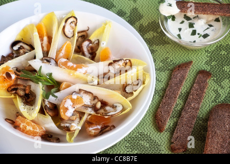 Le cicorie di Bruxelles con insalata di arance mandarini, funghi e pinoli Foto Stock