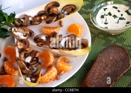 Le cicorie di Bruxelles con insalata di arance mandarini, funghi e pinoli Foto Stock