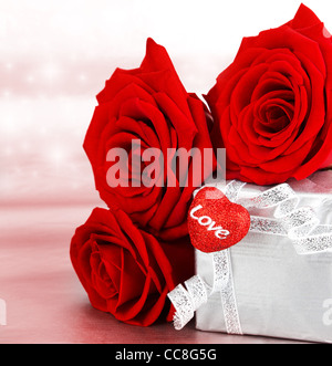 Regalo romantico & rose rosse, isolato su sfondo rosa, il concetto di amore Foto Stock