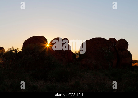 La luce del mattino in rosso di massi di granito e gengive fantasma del diavolo area marmi nei Territori del Nord Australia. Foto Stock