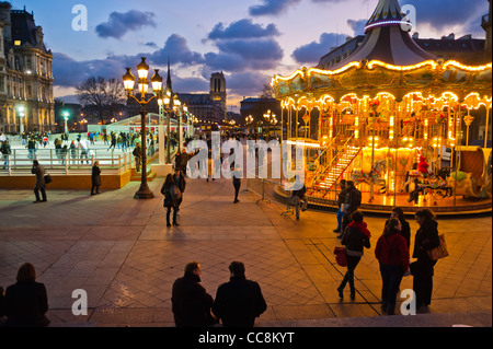 Parigi, Francia, la folla che cammina, la storica Piazza della città, di fronte all'edificio del municipio, al tramonto, con anello di pattinaggio e giostra, giostra di antiquariato, lampioni, lampioni di Parigi Foto Stock