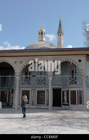 Turista femminile esplorando il Topkapi Palace Istanbul cupola e minareto torre Foto Stock