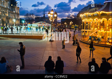 Parigi, Francia, Piazza della città Scenic di fronte all'edificio del Municipio, al Dusk, con Merry-Go-Round, lampione di Parigi Foto Stock