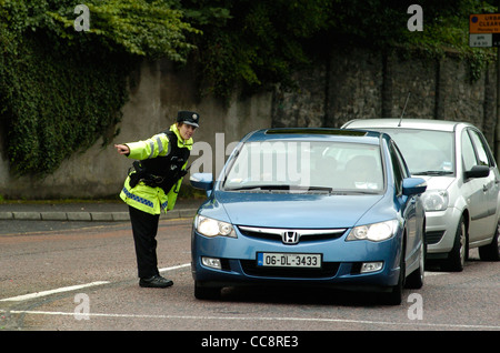 Femmina armati PSNI Officer dirige il traffico in Londonderry, Irlanda del Nord, Regno Unito Foto Stock