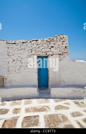 Blue porta di legno su un muro bianco con cielo blu, a Mykonos, Grecia Foto Stock