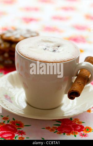 Close-up di deliziosa cioccolata calda con cioccolato spruzza, la stecca di cannella e panpepato cookie Foto Stock