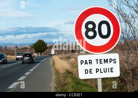 Un cartello stradale sulla D909 al di fuori di Beziers avverte che il limite di velocità viene ridotta a 80 km/ora quando piove. Foto Stock