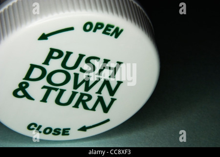 A prova di bambino bottiglia di prescrizione sul lato che mostra il coperchio Foto Stock