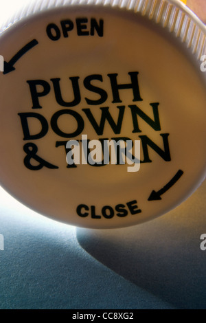 A prova di bambino bottiglia di prescrizione sul lato che mostra il coperchio Foto Stock