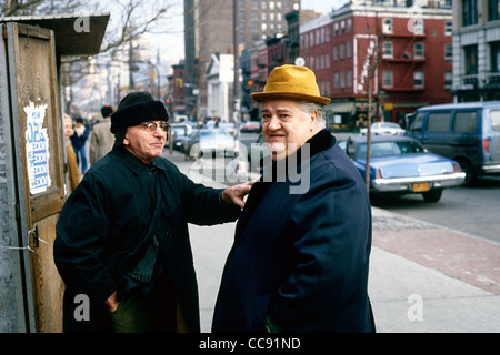 Una familiare scena di strada -nativa New Yorchesi pausa per chattare in una città street USA Foto Stock