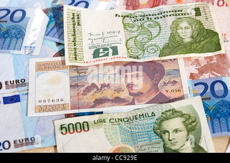 Pre Euro monete nazionali franchi francesi sterline irlandesi lire italiane sulla pila di euro Foto Stock